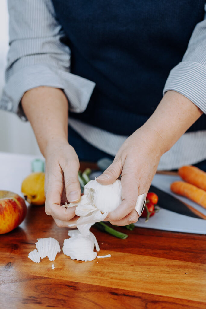 Personal Branding Foto einer Ärztin, die einen Salat zubereitet. Fokus auf den Knoblauch