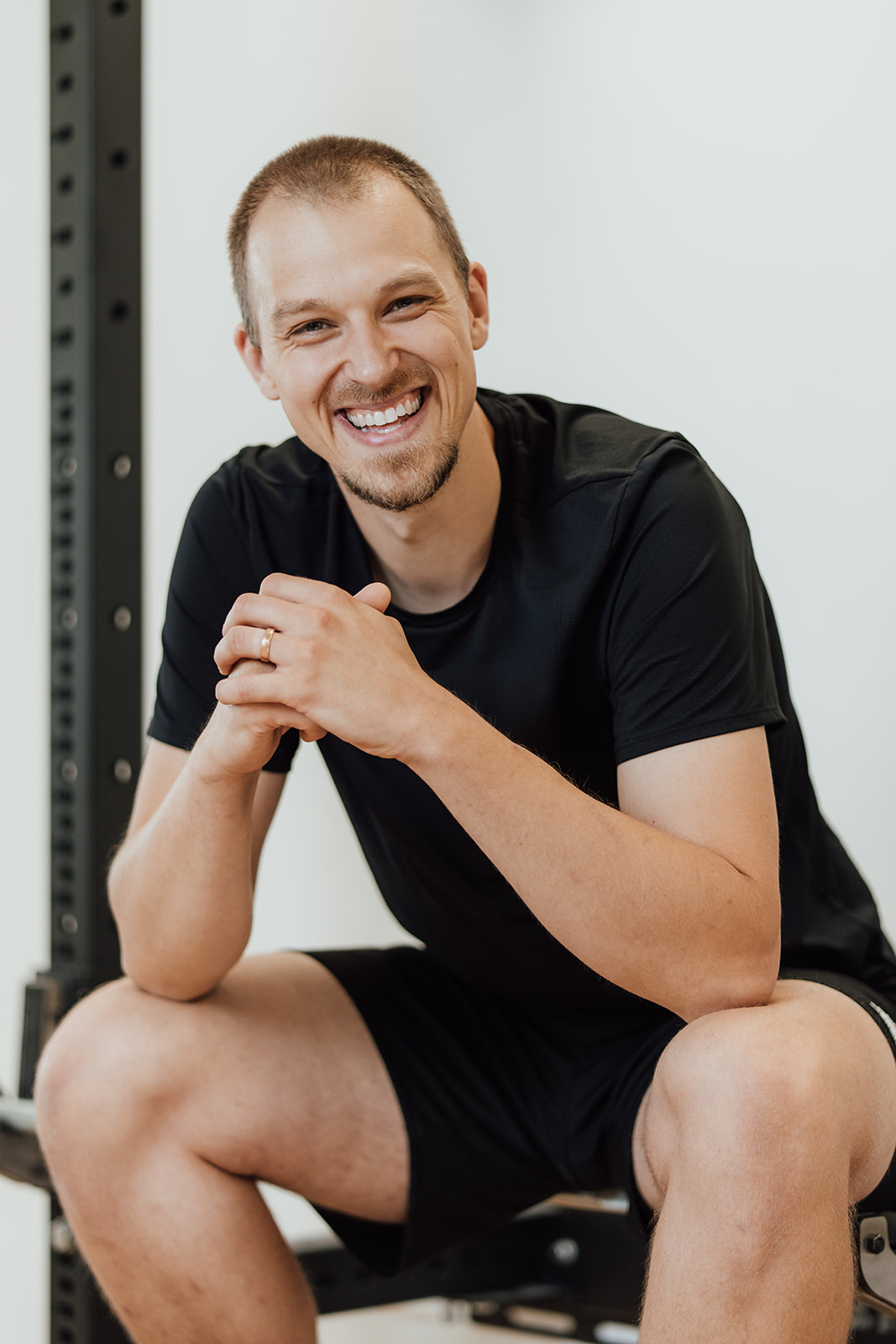 Authentisches Businessfoto eines Mannes, der seine Hände auf Brust und Bauch gelegt hat und in die Kamera lächelt